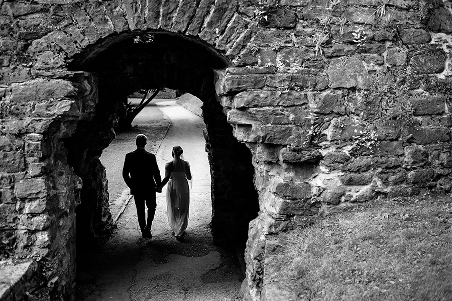 Bride and groom walk through tunnel after wedding ceremony.