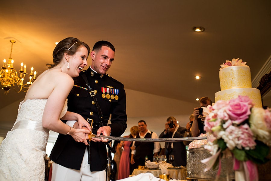 Bride and Marine groom cut the cake with Marine's NCO sword.