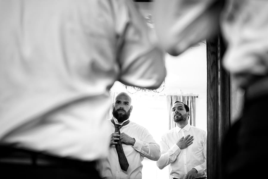 Groom and groomsmen tying their ties in the morning.