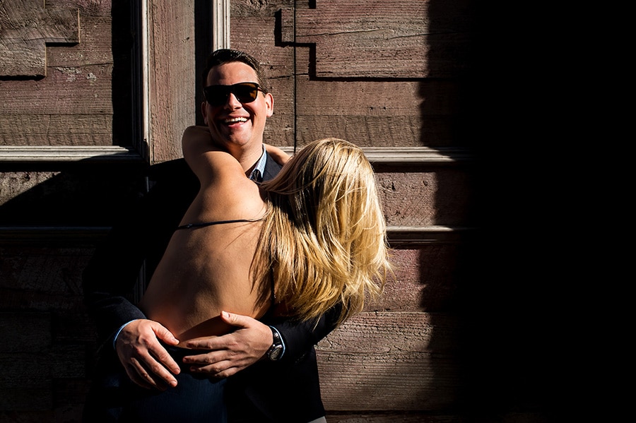 Bride-to-be laughing and hugging her groom-to-be during their engagement session in NYC.