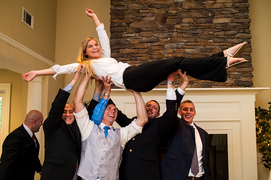 Photographer's assistant lifted into the air by the groomsmen.