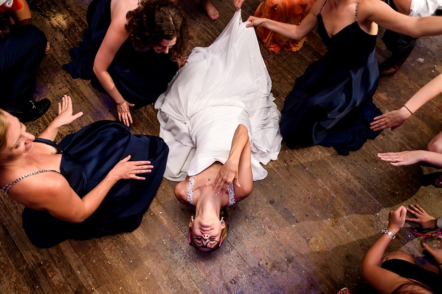 Bride lays back on dance floor.