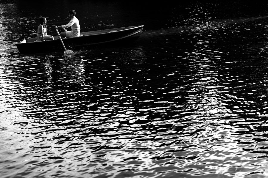 Engaged couple row in a boat in Central Park's lake.