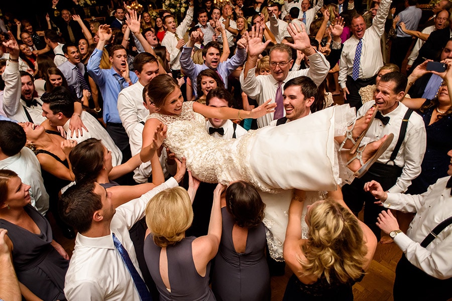 Bride crowd surfing on wedding guests shoulders during wedding reception!