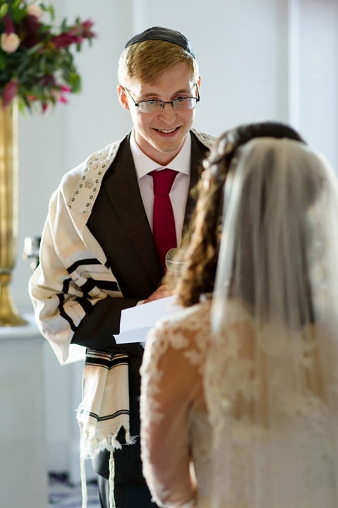 Groom looks at bride during his wedding vows.