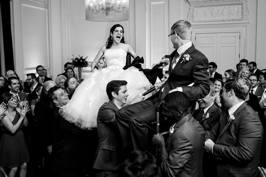 Bride and groom are lifted in chairs during the Horah at their reception.