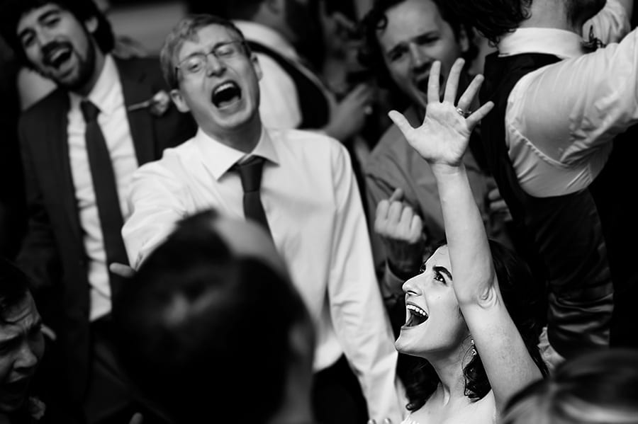 Bride throws her arm into the air during wedding reception.