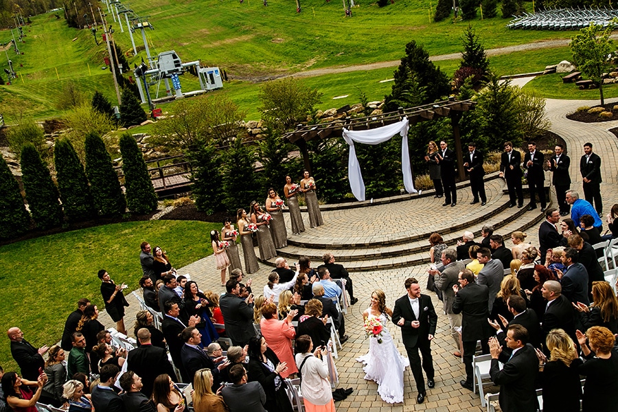 Bride and groom walk down aisle after wedding ceremony at Bear Creek Mountain Resort.,