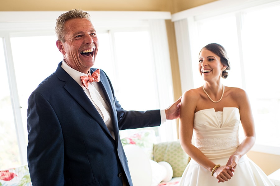 Emotional father of the bride laughing with his daughter before her wedding.