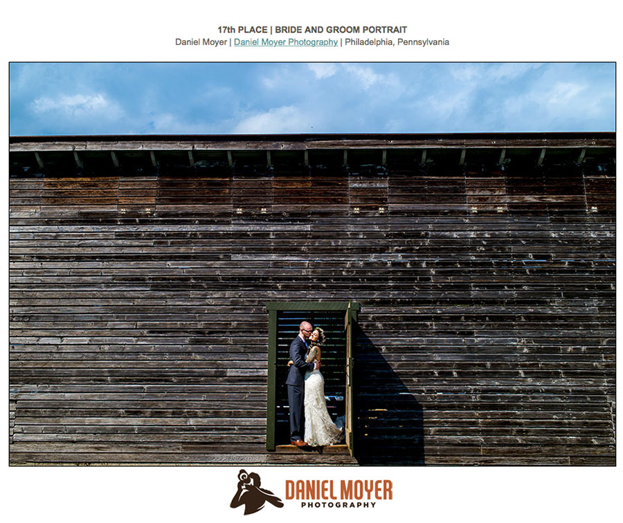 Bride and groom framed in the doorway of a chicken coop.